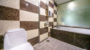 A bathroom with a toilet, shower, and bathtub.