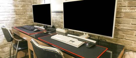 Un espace de travail comprenant deux écrans, un clavier et une souris, le tout posé sur un bureau.