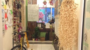 Un pasillo estrecho con una bicicleta, un tablón de anuncios y varias decoraciones.