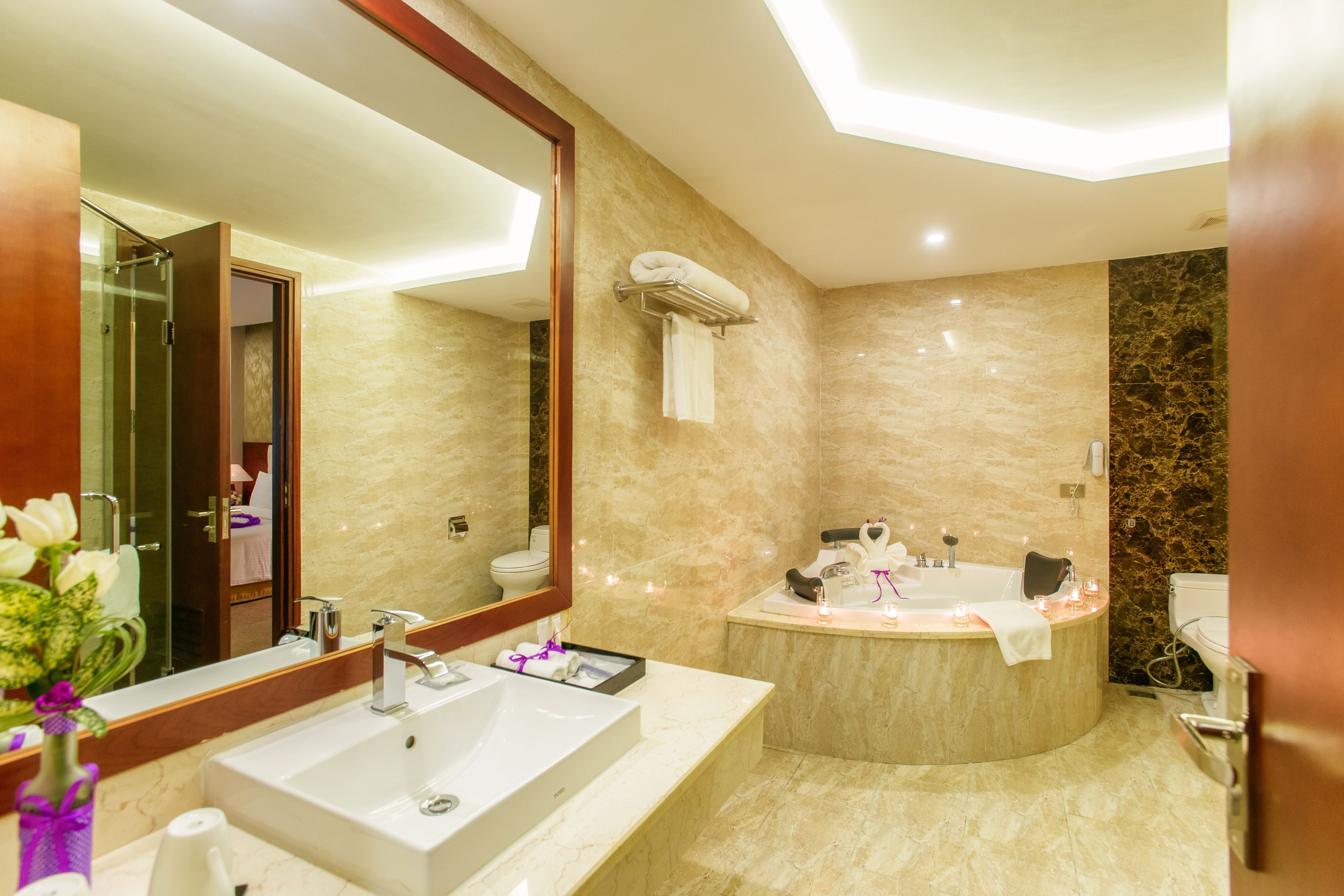 Ein modernes Badezimmer mit großem Spiegel, zwei Waschbecken, einer Badewanne und einer Dusche.