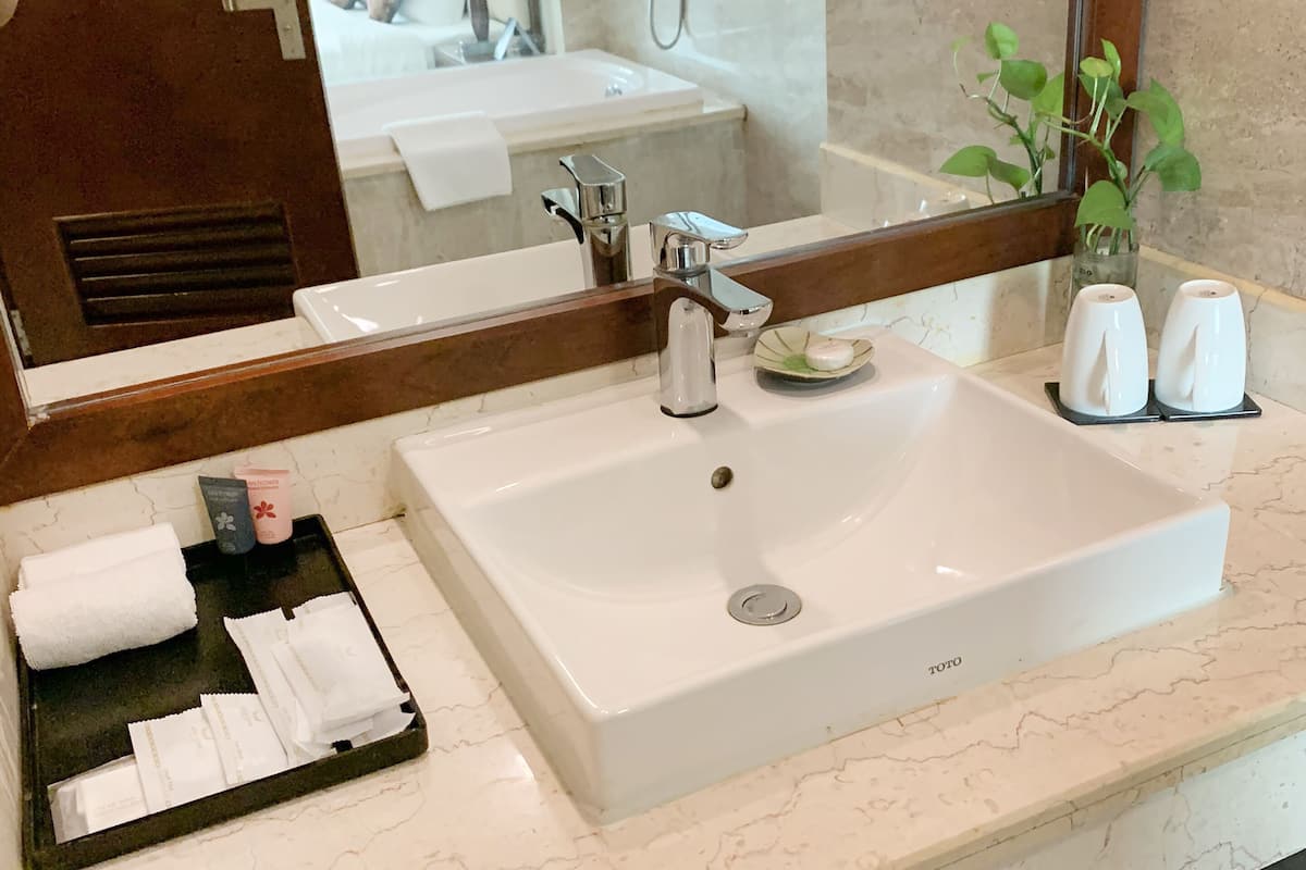 deluxe twin room | bathroom | rainfall showerhead, designer toiletries, hair dryer, towels
