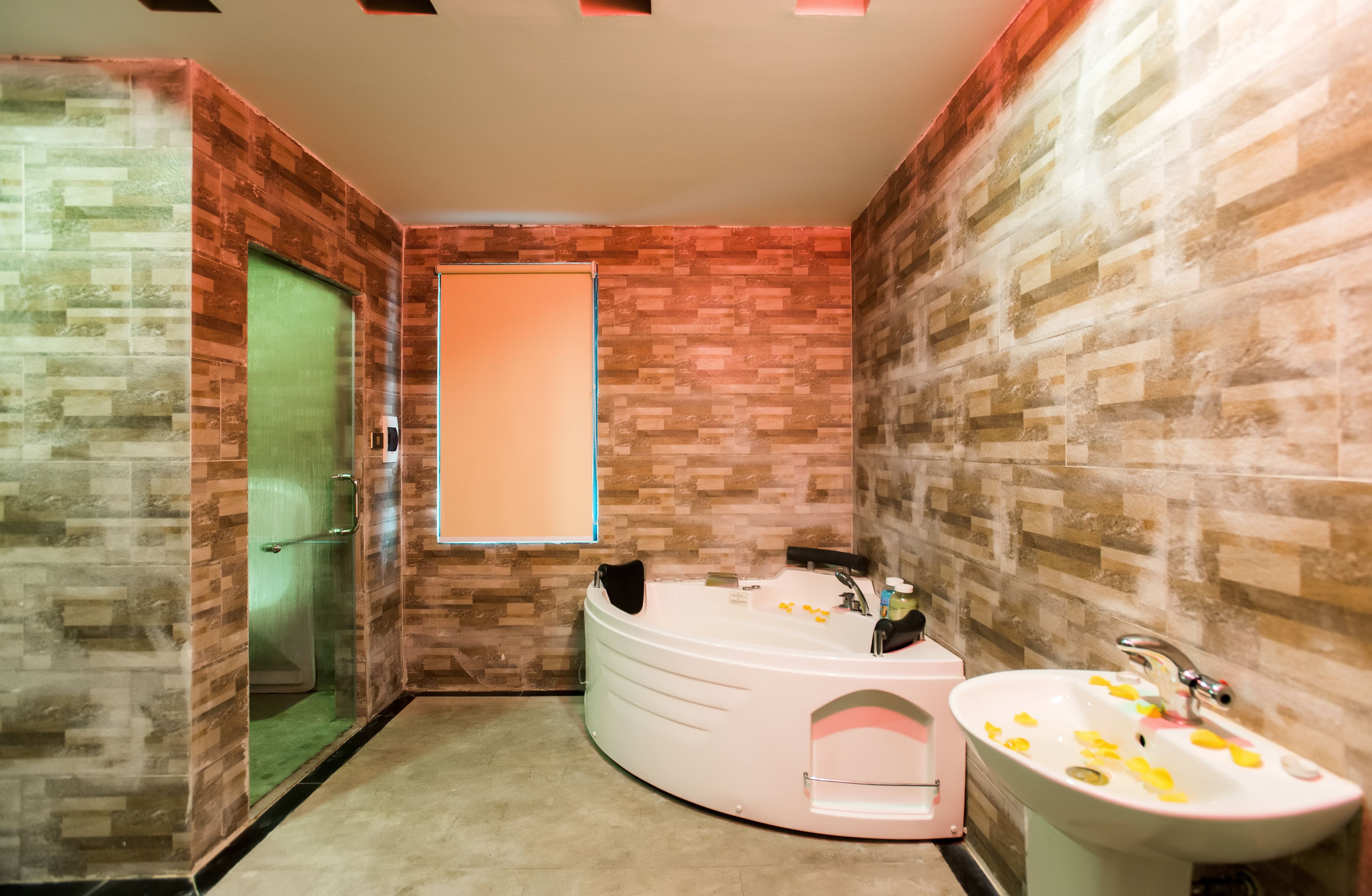 A bathroom with a modern design, featuring a large bathtub, a sink, and a shower area.