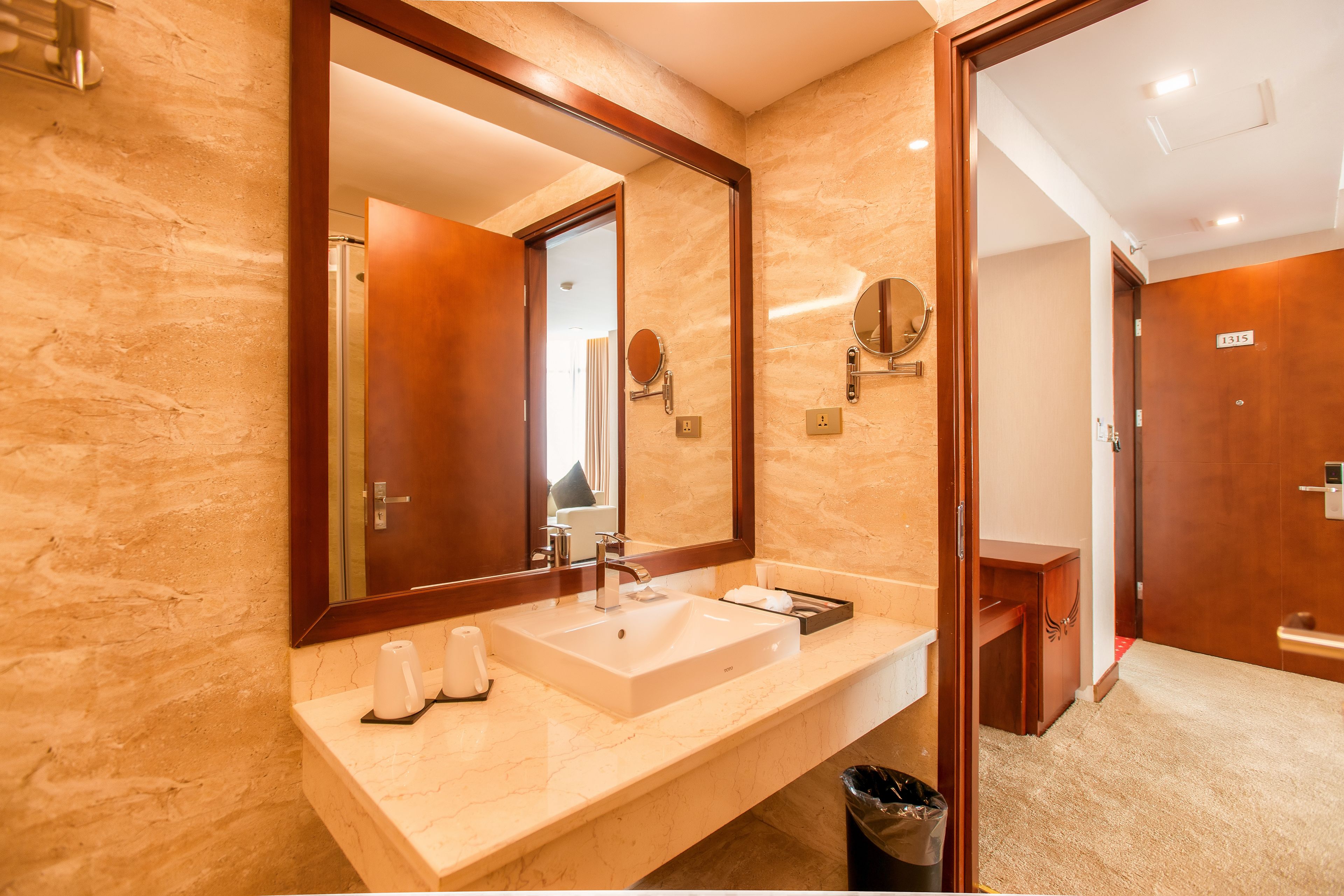 Une salle de bain moderne avec un grand miroir, un lavabo et un meuble-lavabo.