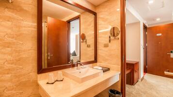 Une salle de bain moderne avec un grand miroir, un lavabo et un meuble-lavabo.