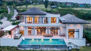 A modern two-story house with a swimming pool, large windows, and a well-maintained lawn. - The Private Pool Villas at Civilai Hill Khao Yai (Pak Chong)