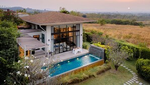 A modern house with a swimming pool, large glass windows, and a view of the countryside. - The Private Pool Villas at Civilai Hill Khao Yai (Pak Chong)