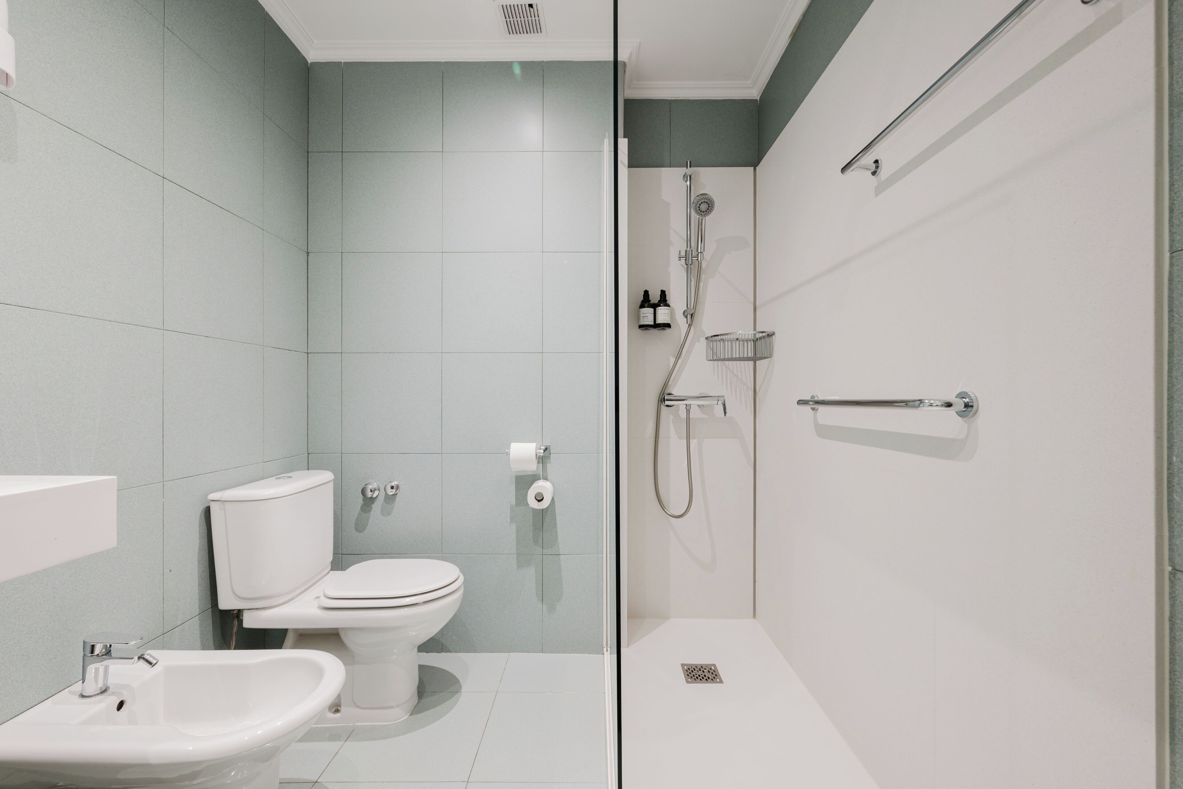 A modern bathroom with a toilet, bidet, and shower.