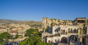 Un pueblo histórico con edificios de piedra antigua, incluyendo una estructura imponente que recuerda a un castillo.