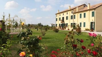Un grande edificio con un giardino antistante.