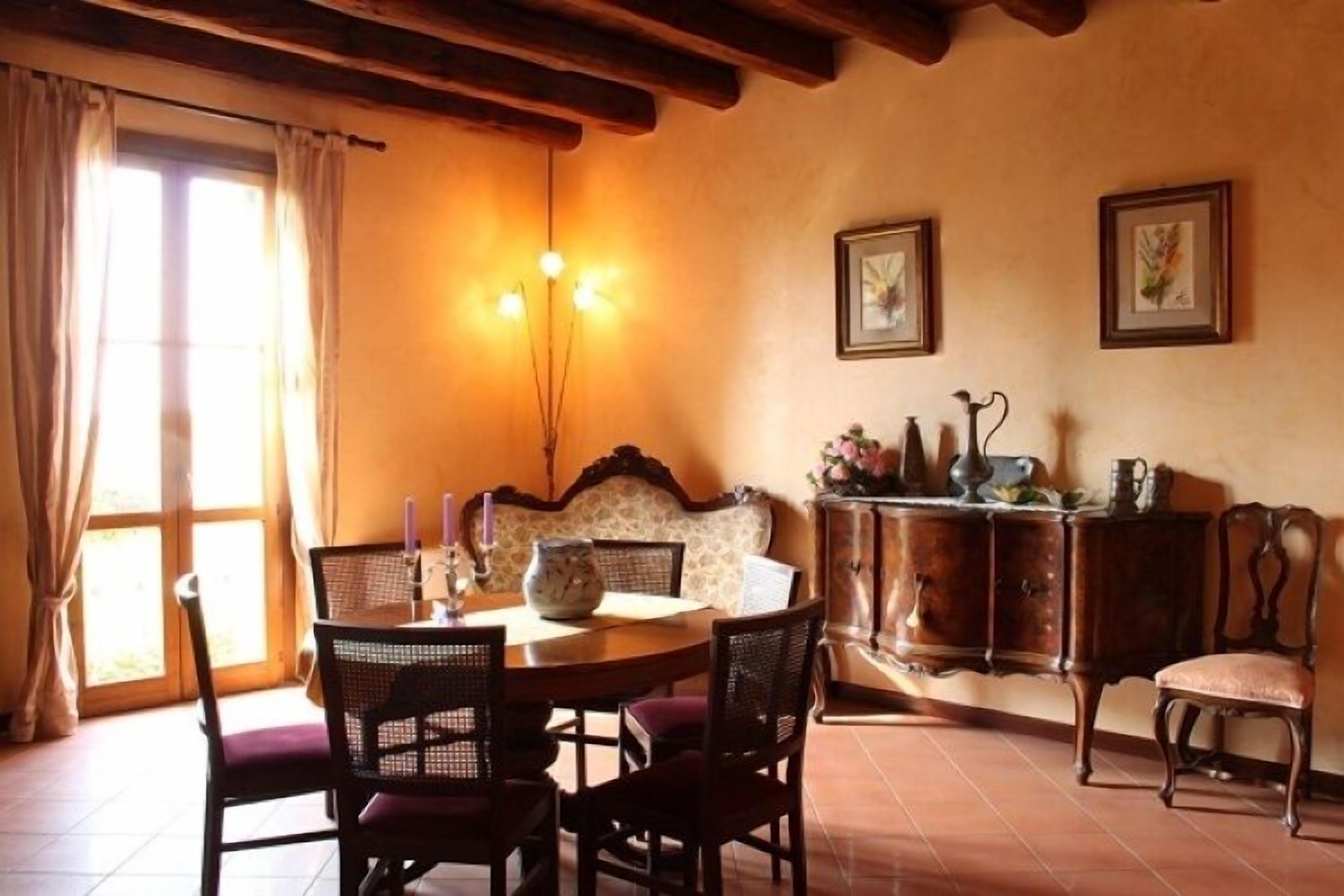 Une salle à manger avec une table ronde, des chaises, un canapé et un buffet.