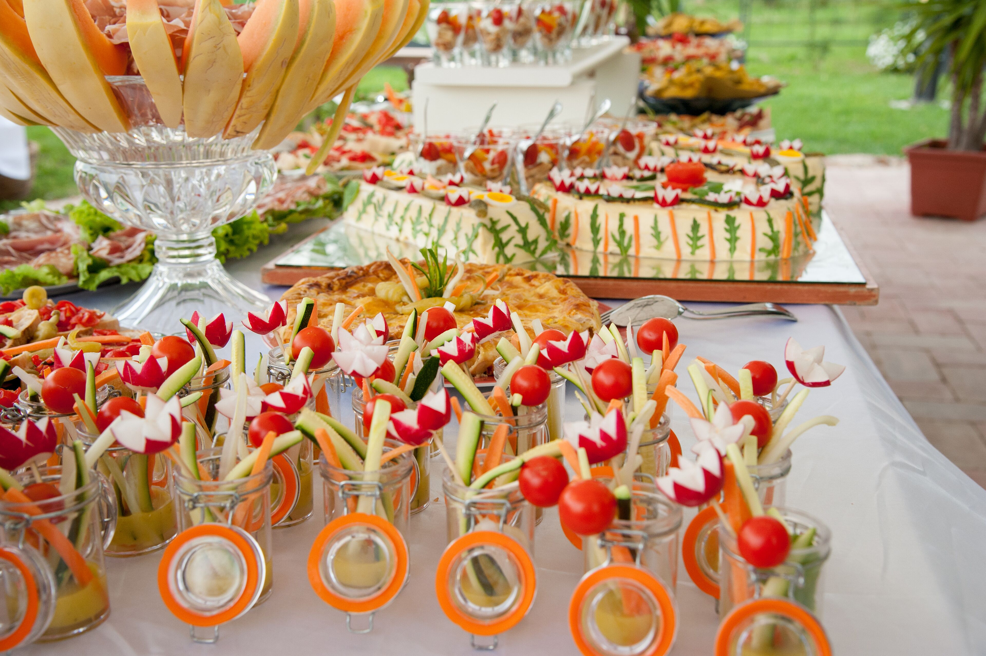 A buffet table with various food items and a decorative centerpiece.