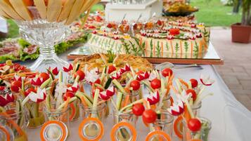 A buffet table with various food items and a decorative centerpiece.