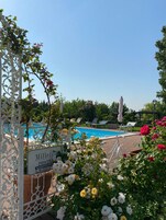 Una piscina al aire libre de temporada, sombrillas