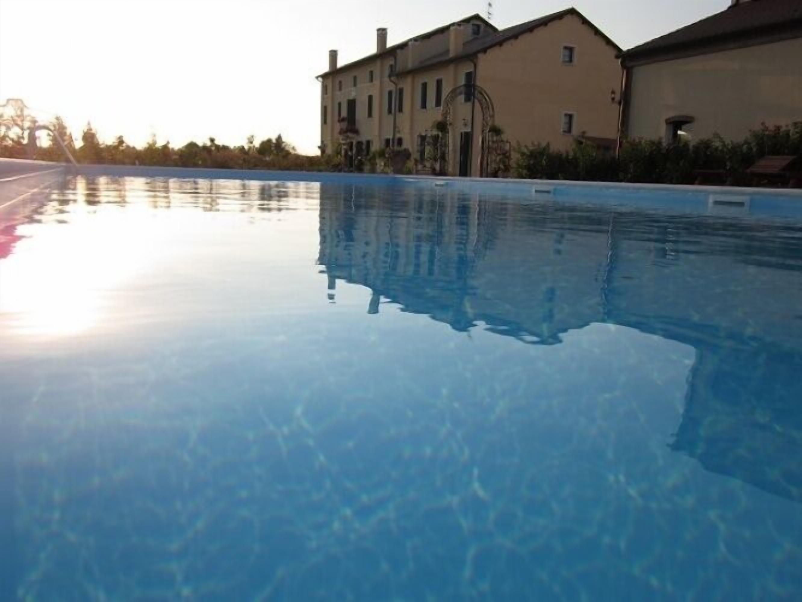 En säsongsöppen utomhuspool, parasoller och solstolar