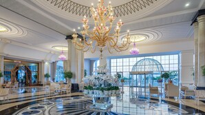 A grand lobby with a large chandelier, marble floor, and elegant furniture. - Rubi Platinum Spa Resort & Suites - All Inclusive (Alanya)