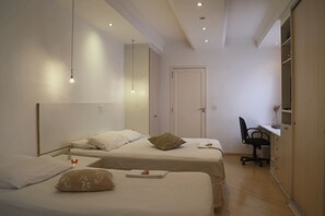 A bedroom with two beds, a desk, and a chair. - Villa Hostel (São Paulo)