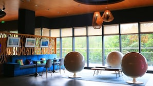 Een modern interieur met een blauwe bank, ronde tafels en bolvormige stoelen.