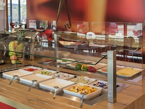 A buffet with various food items and utensils.