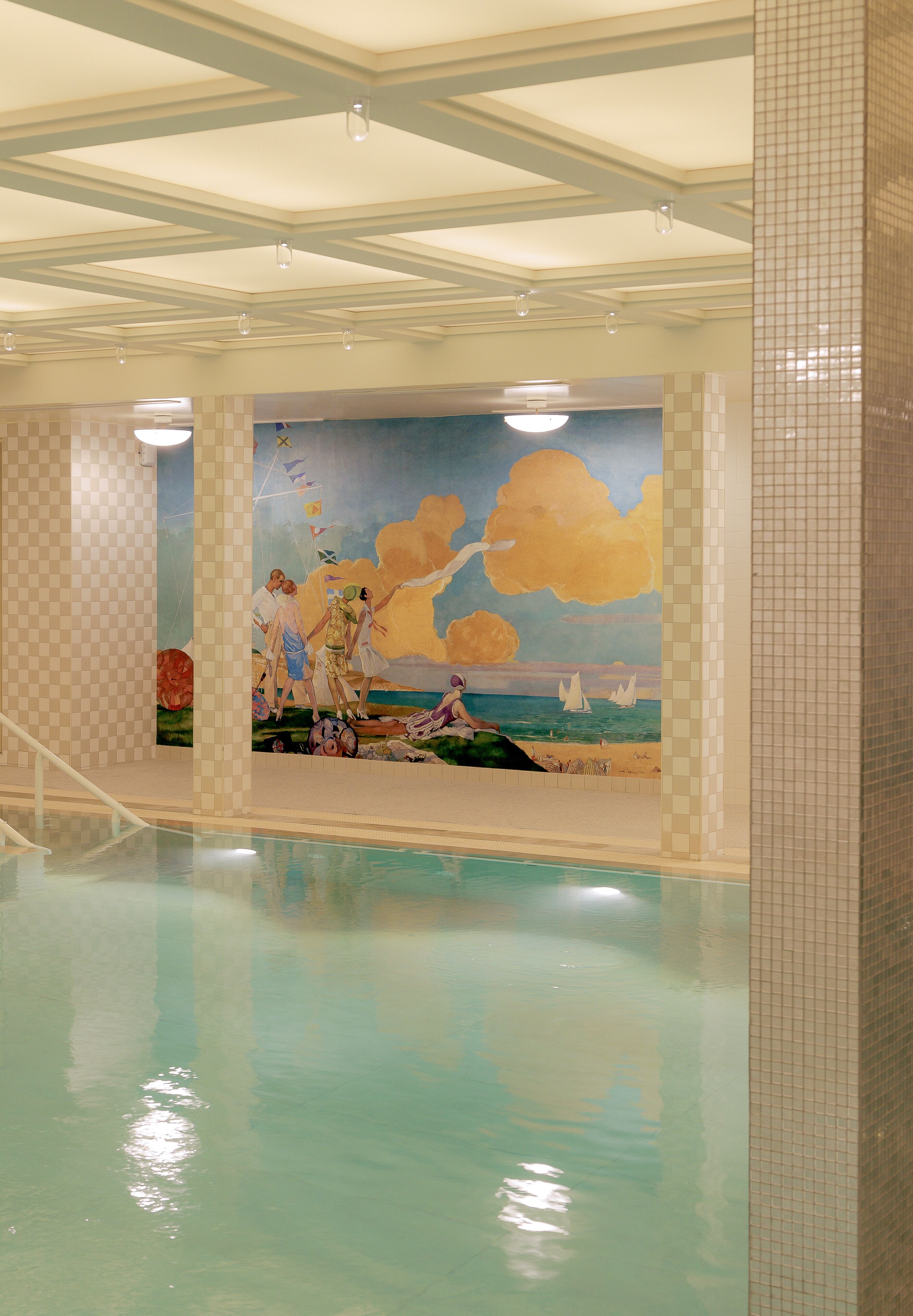 Una piscina con un mural que representa una escena de playa.