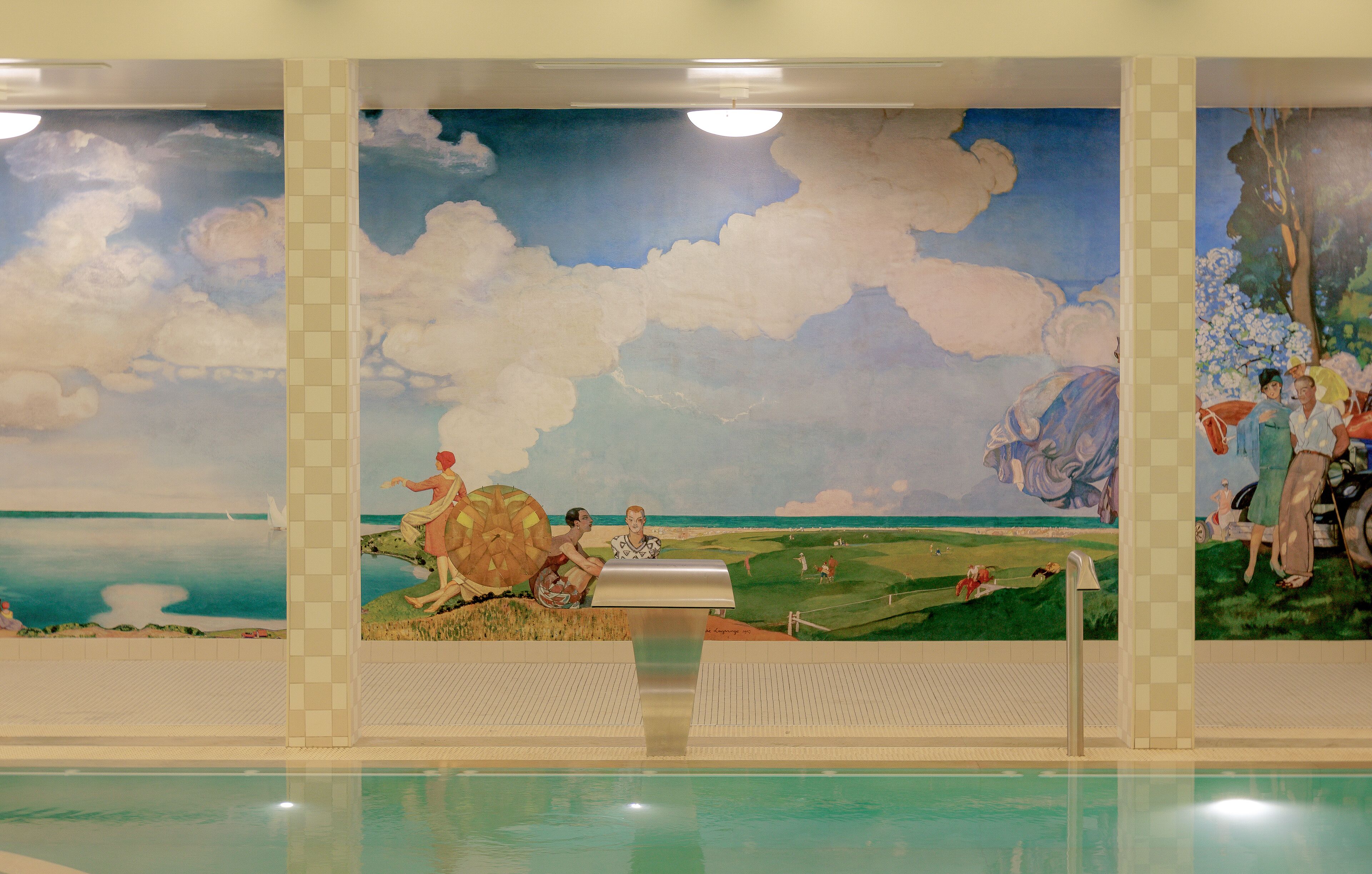 Una piscina con un mural que representa una escena de playa y gente.