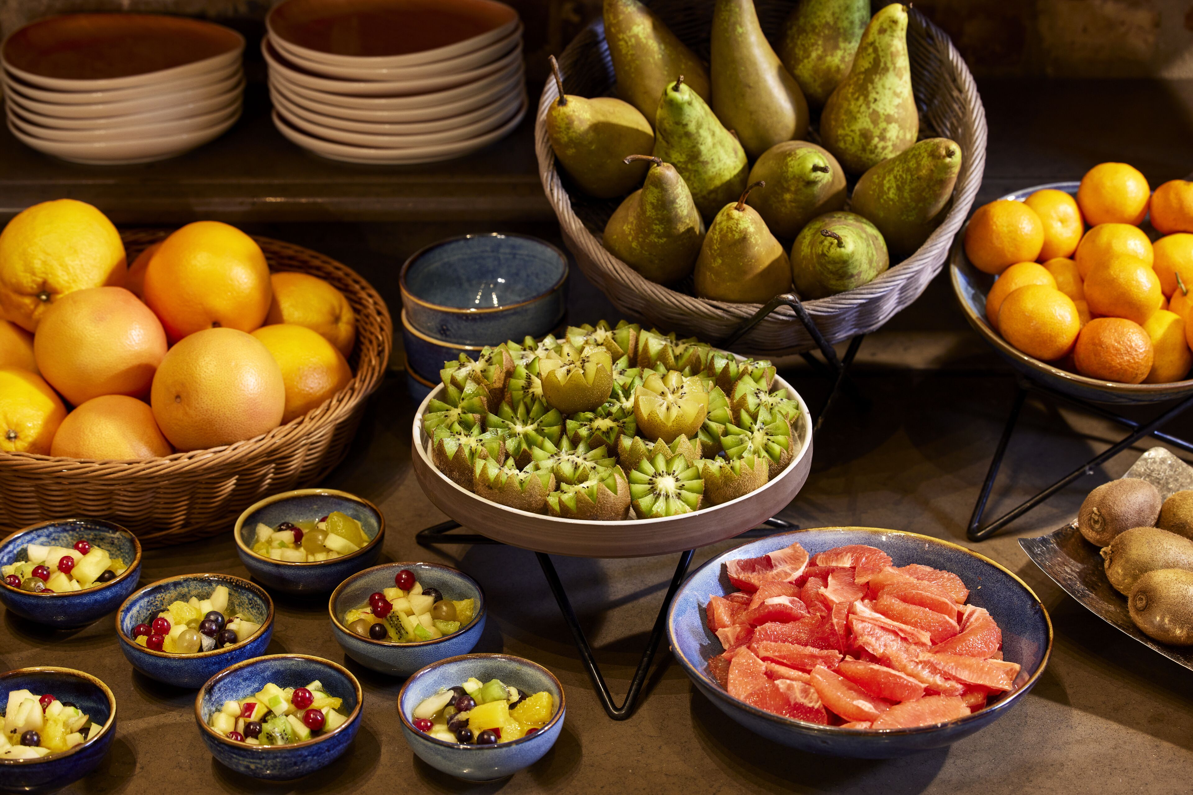 A variety of fruits and bowls on a table.