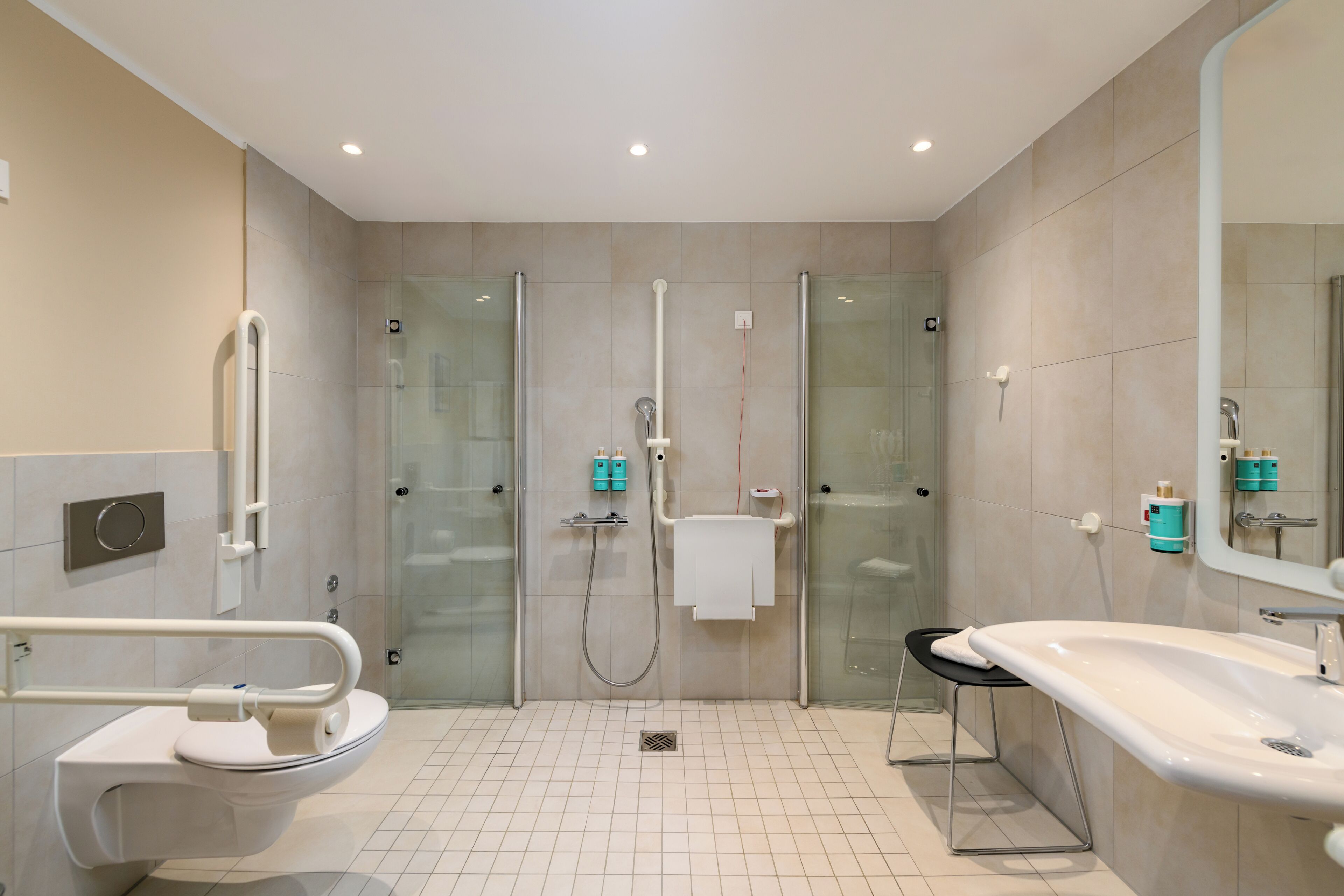 A modern bathroom with a glass-enclosed shower, a white sink, and a toilet.