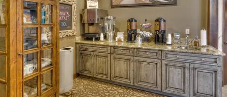 A kitchen with a coffee station, a cabinet with glass doors, and a sign for Star Cafe Nental Breakfast.