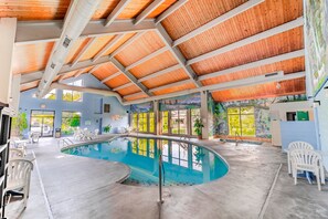 An indoor swimming pool with a wooden ceiling and large windows. - Accommodation By Willow Brook Lodge (Pigeon Forge)