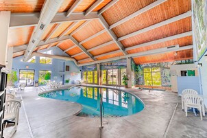 Una piscina techada, una piscina al aire libre de temporada, sombrillas