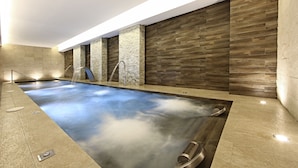 A modern indoor pool with a stone wall backdrop and a built-in water feature. - Iberostar Waves Cala Millor -Adults Only (Sant Llorenc des Cardassar)