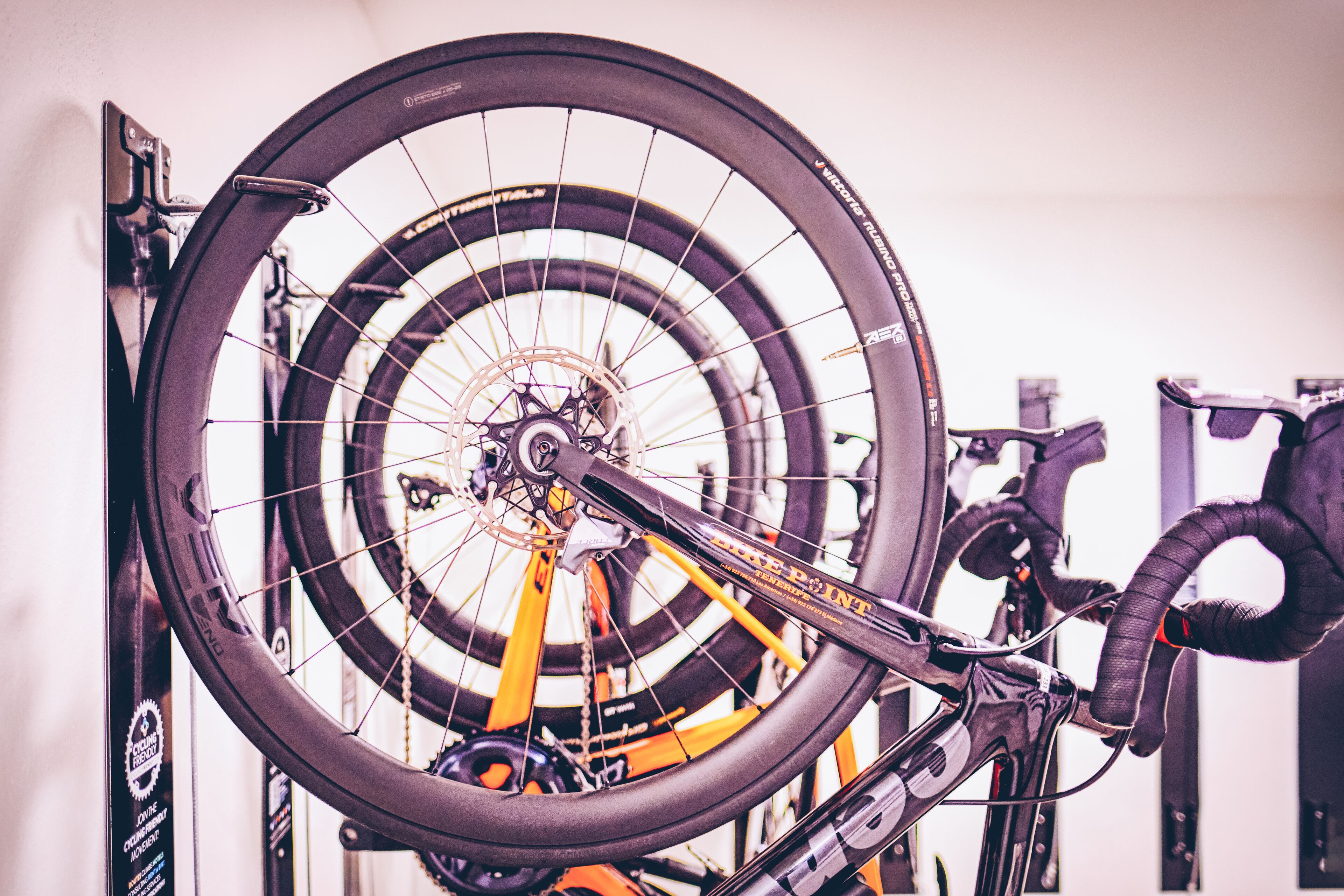 Un vélo doté d’une grande roue arrière, monté sur un support, probablement dans un atelier de réparation ou un espace de stockage.