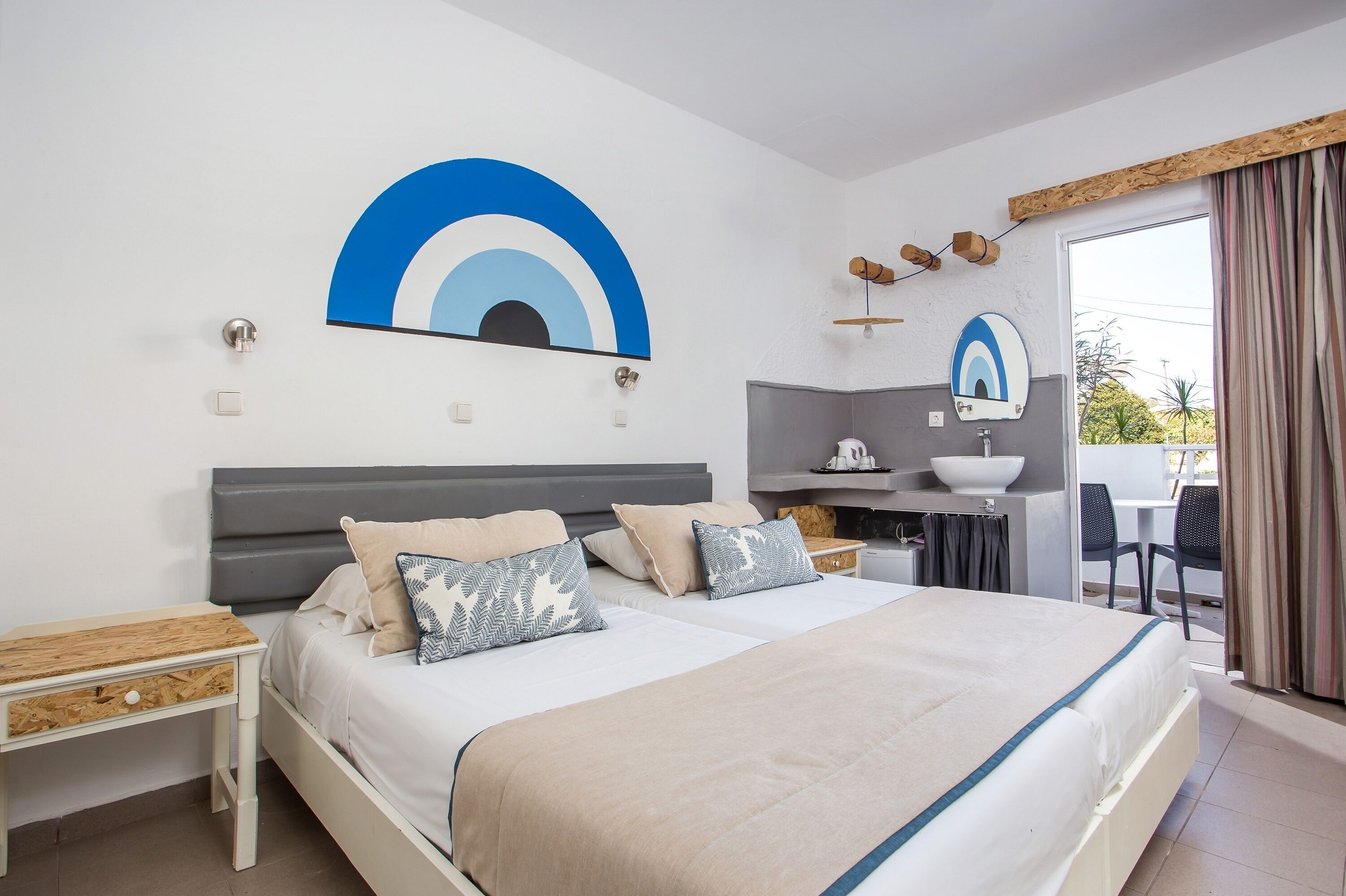 Una habitación de hotel con cama, mesitas de noche, escritorio y zona de baño.