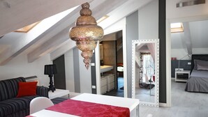 A modern bedroom with a sloped ceiling, a large mirror, a bed, and a table with a red tablecloth. - Venice Art Design Bed & Breakfast (Mestre)
