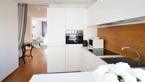 A compact kitchen with white cabinetry, a built-in oven, a microwave, and a sink. - Venice Art Design Bed & Breakfast (Mestre)