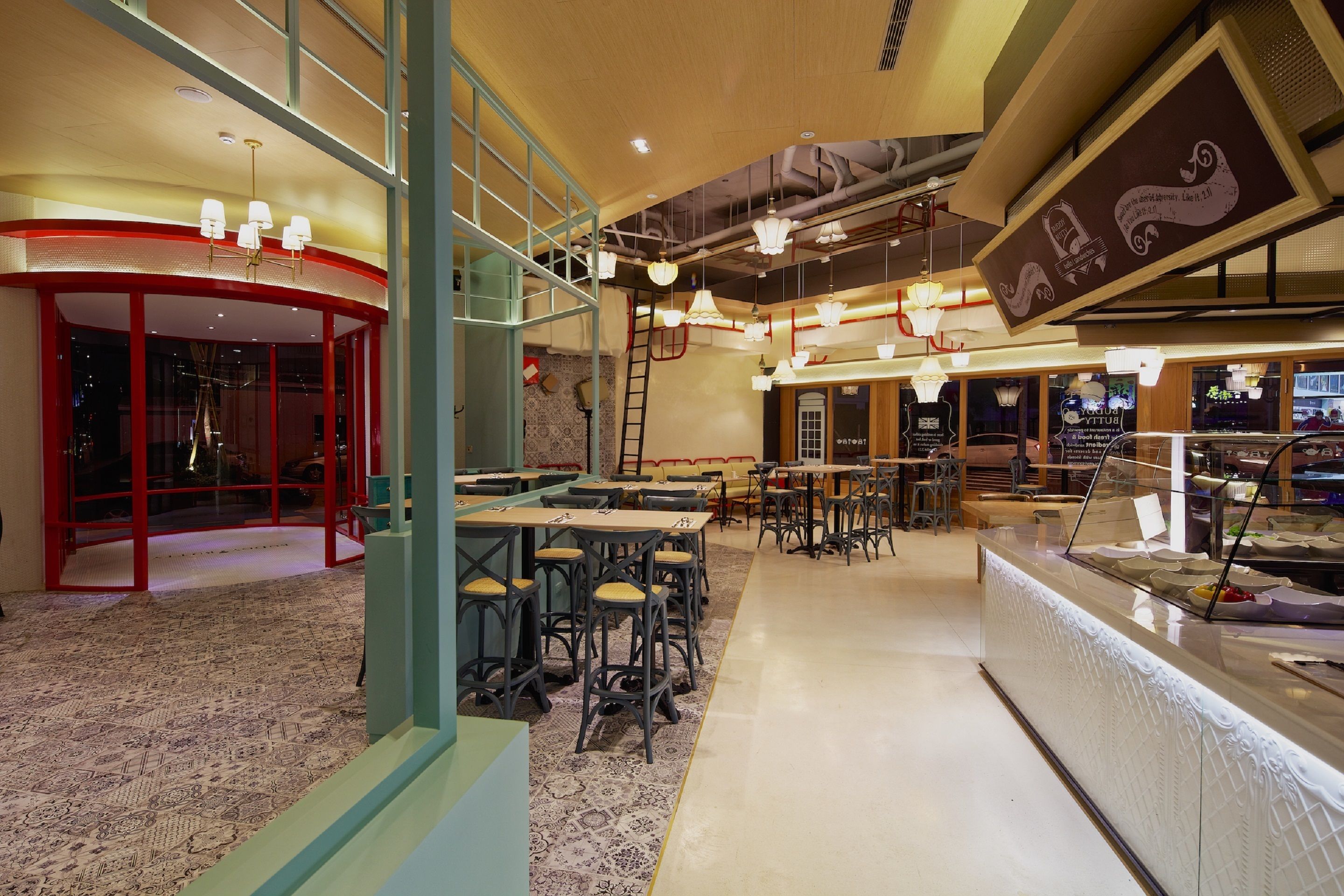 A spacious restaurant with high ceilings, hanging lights, and a central bar area.