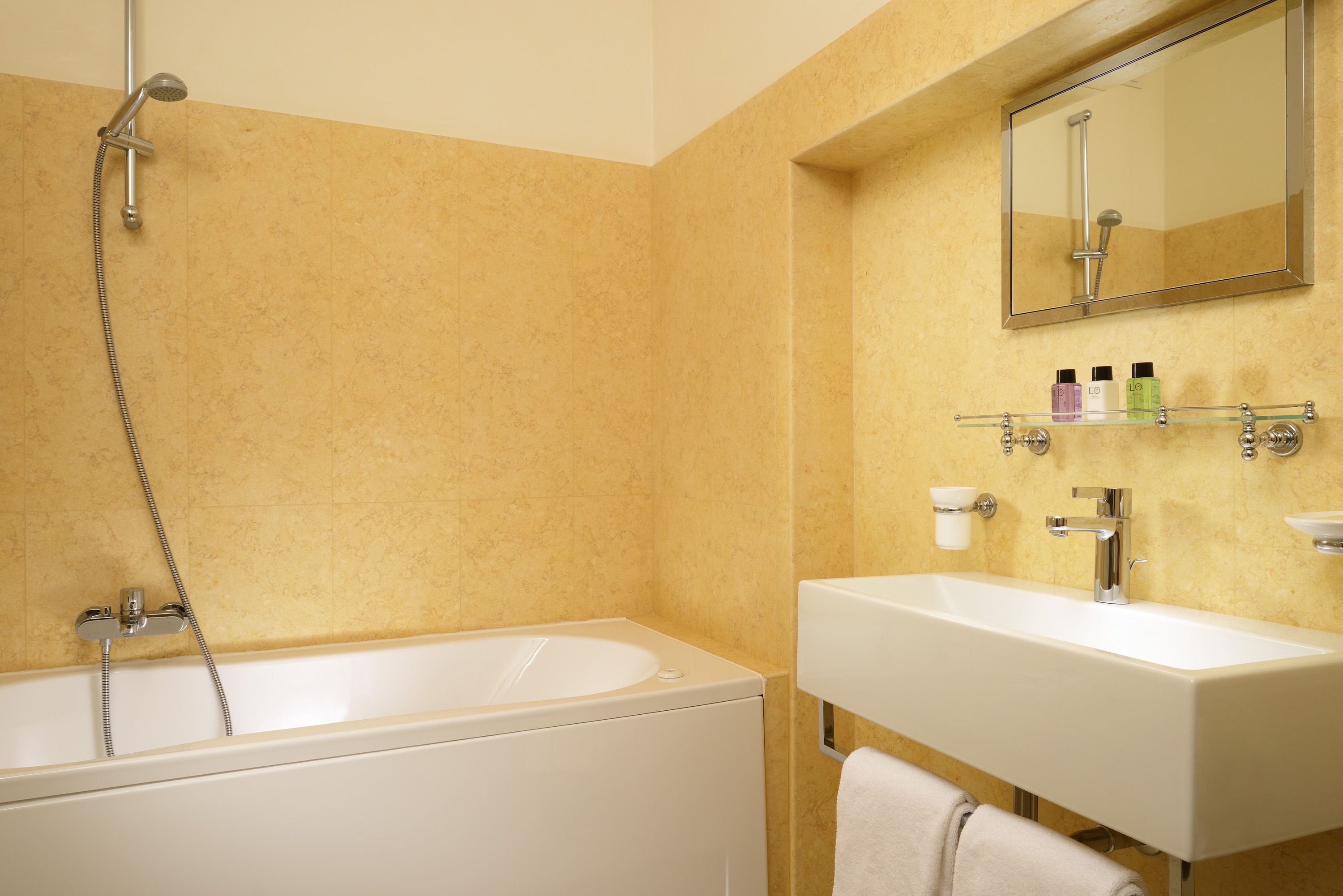 A bathroom with a bathtub, a sink, and a mirror.