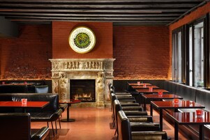 Un restaurante con paredes de ladrillo, chimenea y asientos de cuero.