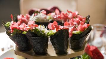 A tray of appetizers with leafy greens and pink flowers.