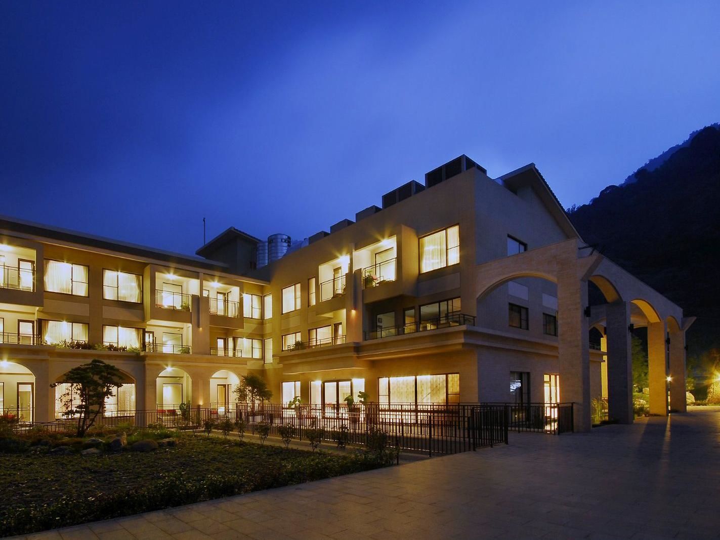 A multi-story hotel with a courtyard, featuring balconies and large windows.
