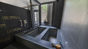 A modern bathroom with two separate tubs, a glass door leading outside, and a potted plant visible through the door. - Tai Yi Red Maple Resort (Puli)