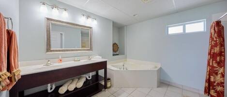 A bathroom with a double sink vanity, a large mirror, a bathtub, and a shower curtain.