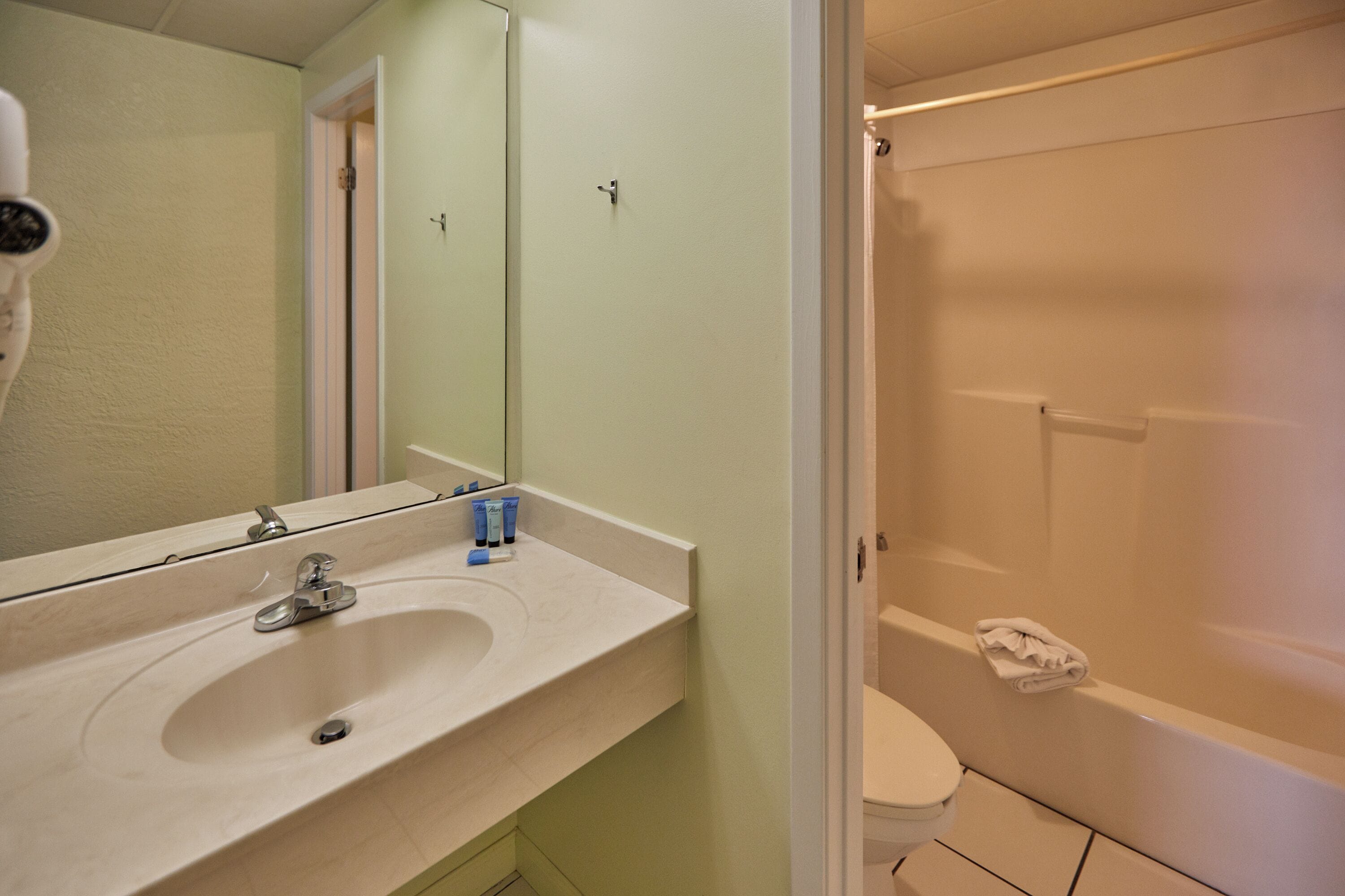 Une salle de bain avec un lavabo, un miroir et une douche.