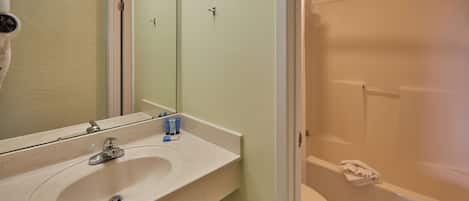 Une salle de bain avec un lavabo, un miroir et une douche.