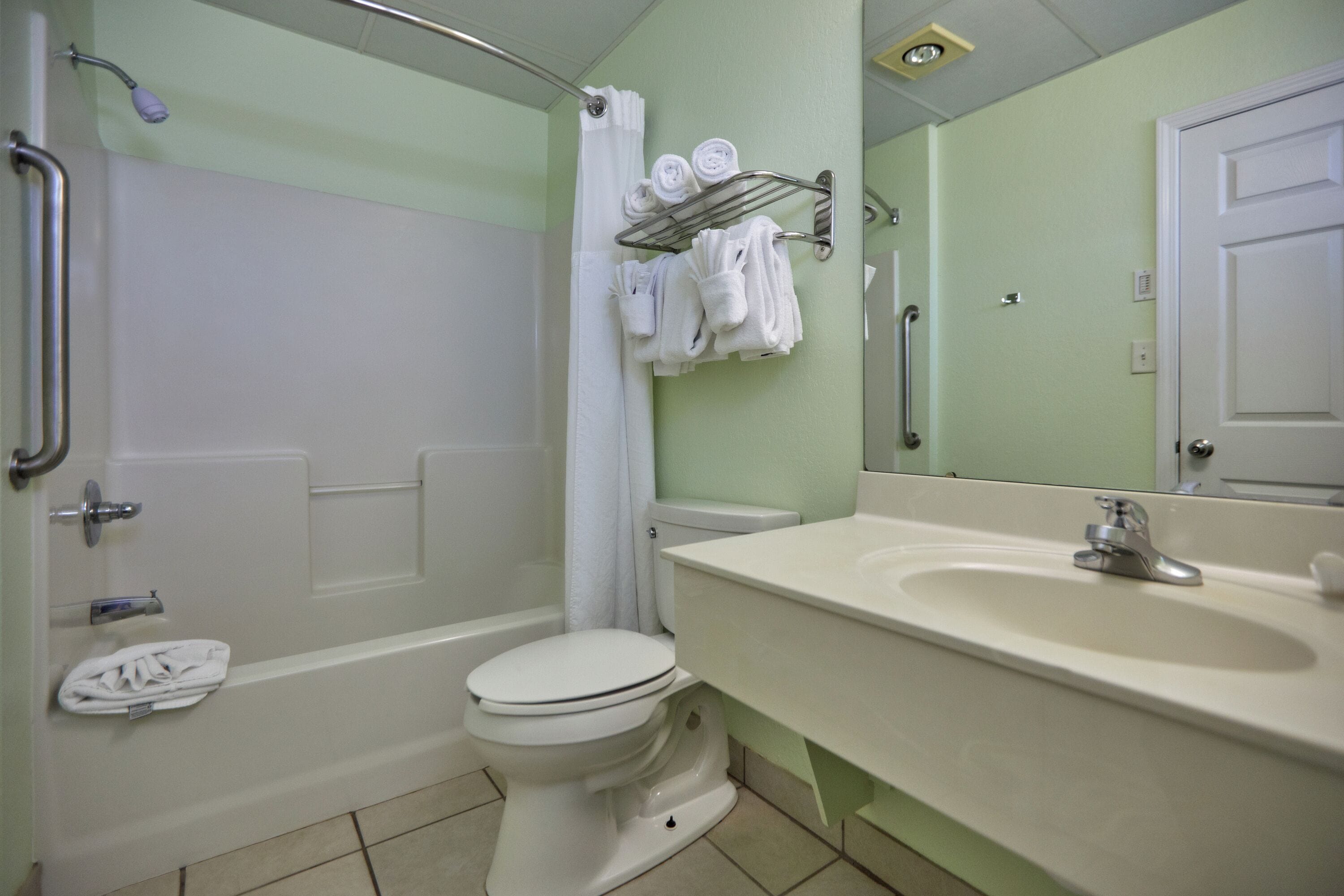 Ein Badezimmer mit Badewanne, Toilette, Waschbecken und einem Handtuchhalter mit Handtüchern.