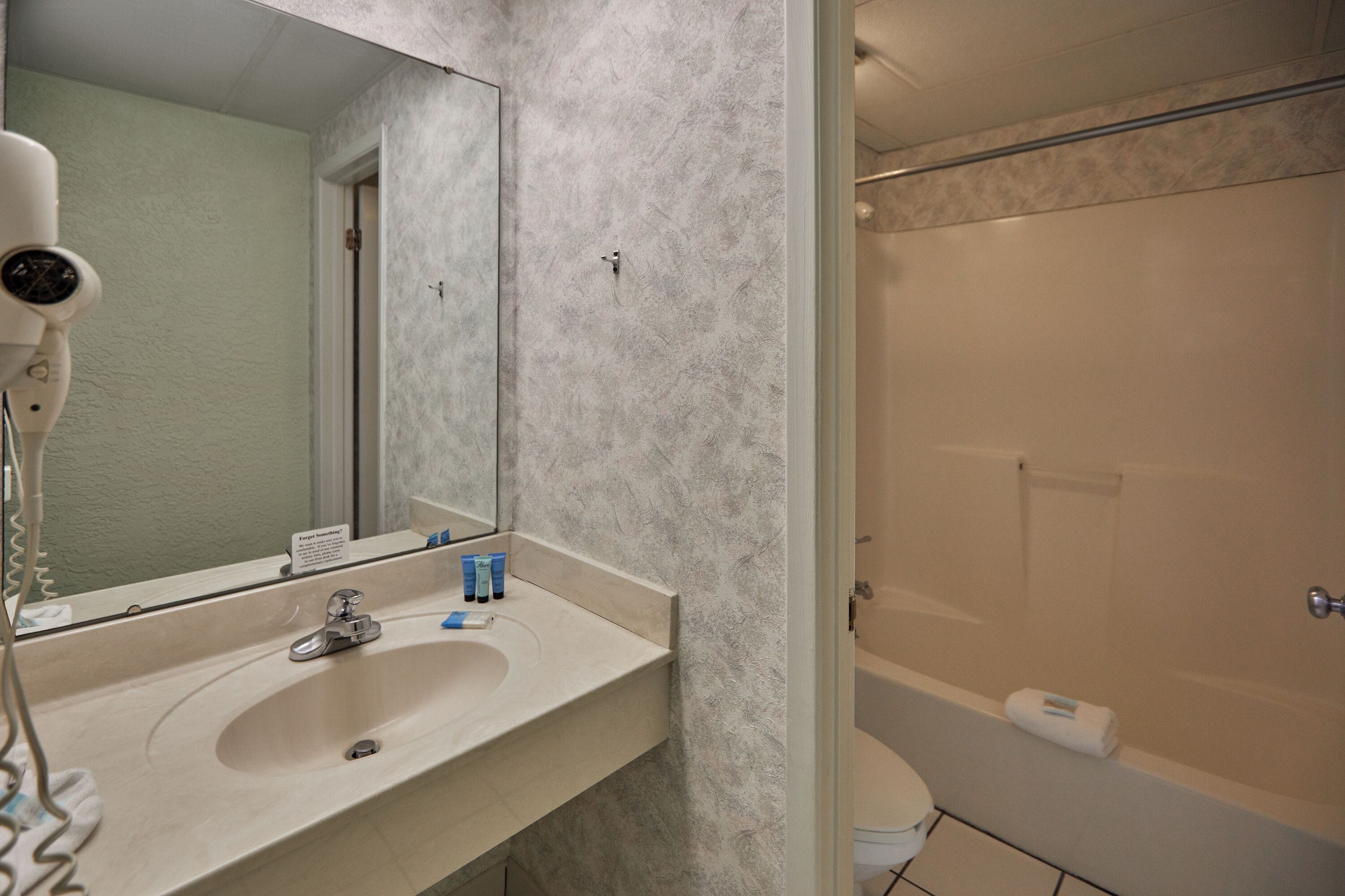 Une salle de bain équipée d’un lavabo, d’un miroir et d’un espace douche.