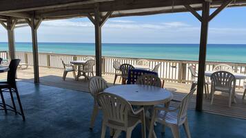 Relax in a covered outdoor seating area with a stunning ocean view from the wooden deck.