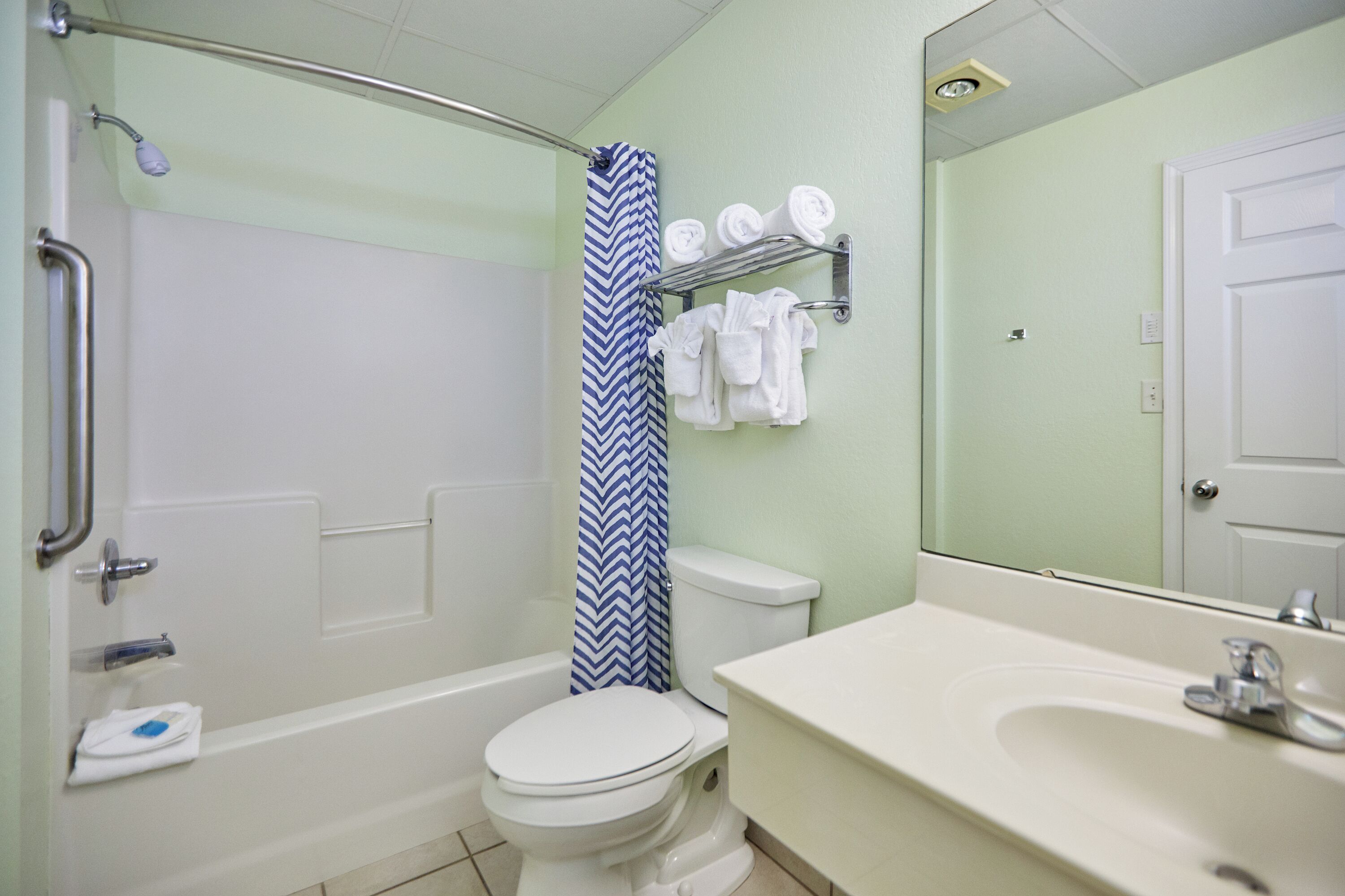 Une salle de bain équipée d’une douche, de toilettes, d’un lavabo et d’un porte-serviettes.