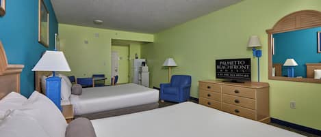 A hotel room with two beds, a dresser, a chair, a desk, and a sign indicating the hotel name.