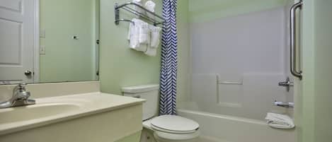 A bathroom with a toilet, sink, shower, and a towel rack.