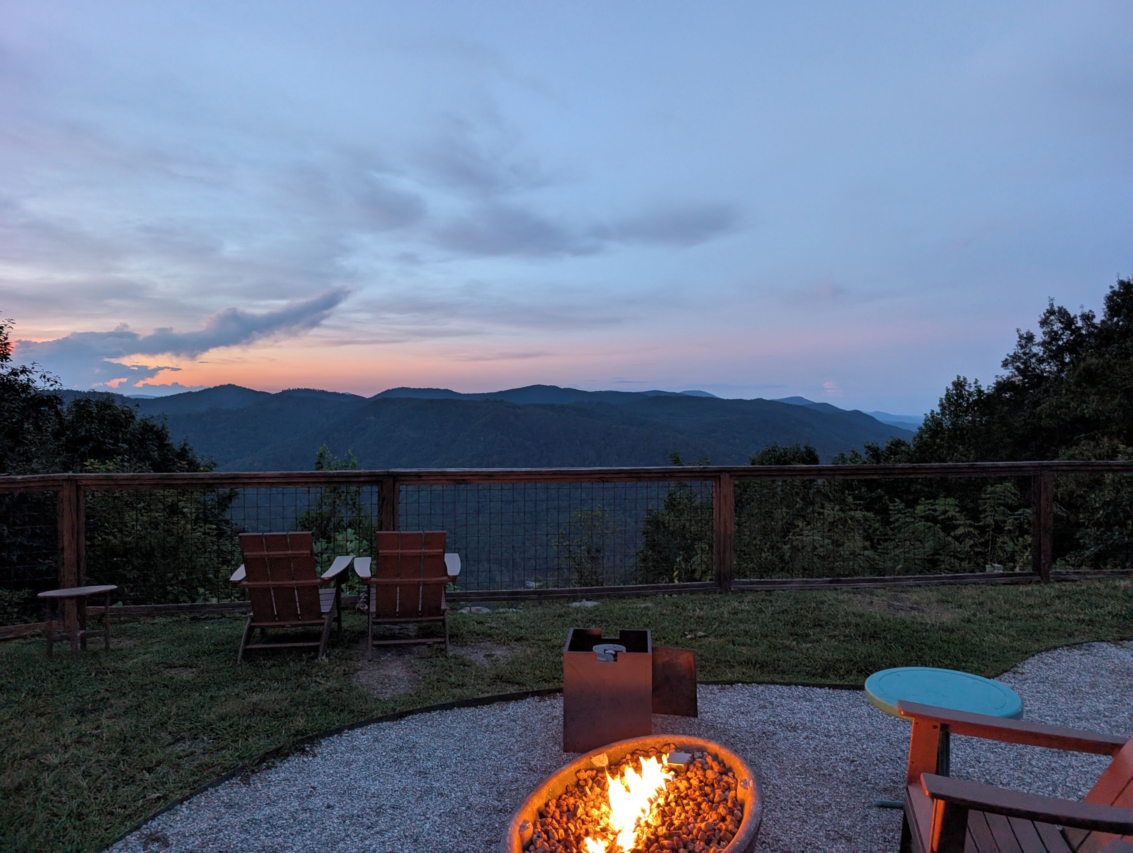 Une terrasse avec un foyer extérieur, des sièges et une vue sur les montagnes.